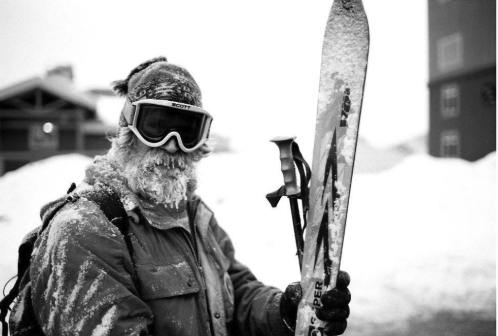 Older skier enjoying a blue ski run on a sunny day